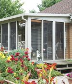 <p>Beautiful flowers arranged around this glass and screen sunroom are perfect to enjoy while relaxing inside!</p>
